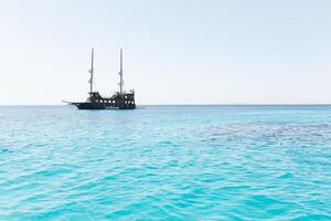 piraat schip Aan de horizon van blauw zee foto