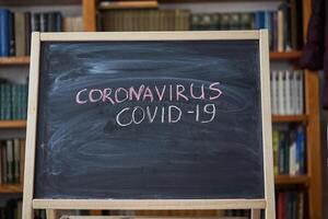 het uitbreken waarschuwing. geschreven wit krijt Aan schoolbord in verbinding met epidemie van coronavirus wereldwijd. foto