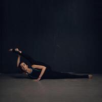 vrouw beoefenen yoga tegen een donker getextureerd muur foto