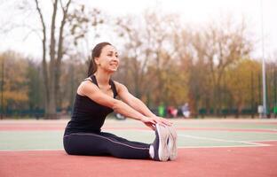 gelukkig meisje aan het doen geschiktheid opdrachten buitenshuis Aan speelplaats. gezond levensstijl. ochtend- training positief emotie glimlachen sportief mensen foto