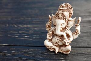 Hindoe god ganesh Aan zwart achtergrond. standbeeld Aan houten tafel foto