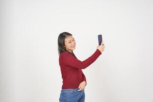jong Aziatisch vrouw in rood t-shirt nemen een selfie foto geïsoleerd Aan wit achtergrond