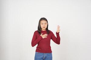 jong Aziatisch vrouw in rood t-shirt vloeken maken een eed geïsoleerd Aan wit achtergrond foto