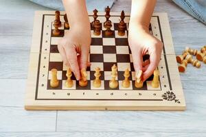 vrouw handen plaatsen stukken Aan een schaakbord foto