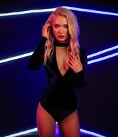 mode kunst foto van elegant model- in verleidelijk zwart zwempak met licht neon gekleurde club schijnwerpers
