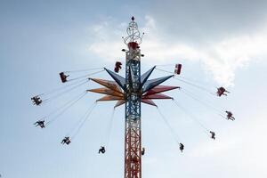 carrousel in een amusement park met de mensen tegen de lucht foto