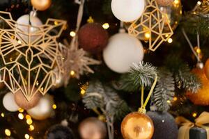 Kerstmis boom decoratie dichtbij omhoog achtergrond. guirlande, ballen, verlichte lichten foto