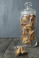 Chinese koekjes in een pot en Aan een tafel Aan een grijs achtergrond met ruimte voor tekst. fortuin vertellen foto