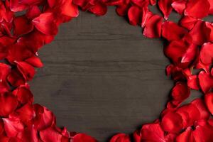 een ronde kader gemaakt van roos bloemblaadjes Aan een donker cement tafel. foto