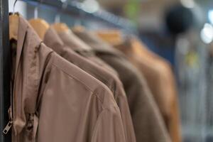 pastel kleding overhemden hangen Aan hangers in een winkel achtergrond. een verscheidenheid van kleren hangende in de garderobe. foto