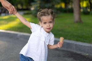 weinig Kaukasisch meisje 3 jaren oud eet ijs room detailopname portret foto