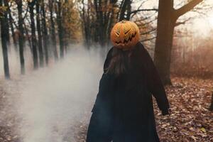 jong vrouw met een halloween pompoen Aan haar hoofd foto