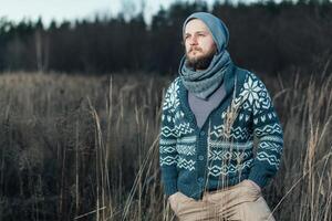 kant visie van hipster elegant Mens. hij staand Aan de herfst veld- en schaven waar hij Gaan foto