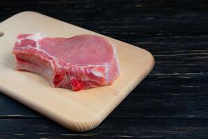 top visie van een stukken rauw varkensvlees karbonade steaks Aan een snijdend bord. foto