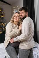 gelukkig familie concept. man knuffel buik zwanger vrouw staand binnen- leven kamer in de buurt sofa foto