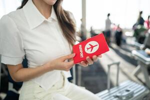 een passagier Bij de luchthaven instappen poort met haar paspoort in hand. foto