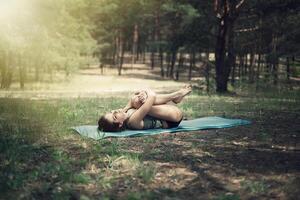 mooi meisje is verloofd in yoga in de Woud foto