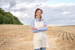 vrouw boer schort staand bouwland glimlachen vrouw agronoom specialist landbouw agribusiness gelukkig positief Kaukasisch arbeider agrarisch veld- foto