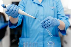 medisch Onderzoek laboratorium. een wetenschapper werken met een pipet en een test buis. wetenschappelijk laboratorium van biotechnologie, ontwikkeling van geneeskunde en Onderzoek in chemie, biochemie en experimenten foto