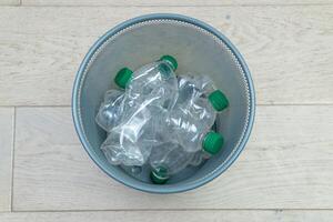 verschillend plastic flessen in de kantoor uitschot kan. ecologie en recycling van verspilling van divers rauw materialen foto