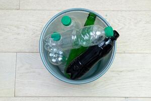 zes verschillend plastic en glas flessen in de kantoor uitschot kan. ecologie en recycling van verspilling van divers rauw materialen foto