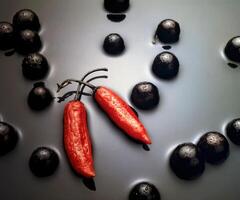 nog steeds leven met rood paprika's en jabuticabas in water foto