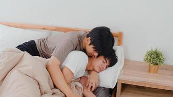 Aziatische homo paar kus en knuffel op bed thuis. jonge aziatische lgbtq-mannen ontspannen rust samen brengen romantische tijd door na het wakker worden in de slaapkamer thuis in het ochtendconcept. foto