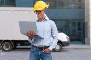 bedrijf. ingenieur arbeider beschermend helm gebruik laptop controles werken werkwijze inspecteur leidinggevende geel moeilijk hoed bril vervoer bedrijf foto