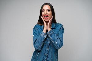 mooi Kaukasisch meisje in een denim jasje poseren in de studio Aan een wit achtergrond. foto