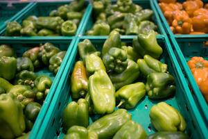 rauw sappig groen klok peper in plastic mand Aan de plank in de supermarkt foto