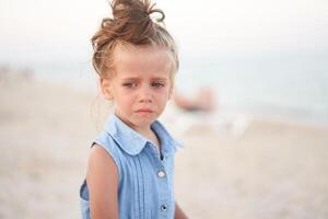 weinig meisje huilen strand. verdrietig zomer vakantie. de kind is verloren foto