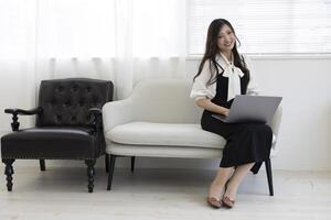 een Japans vrouw controle smartphone door afgelegen werk in de huis kantoor foto