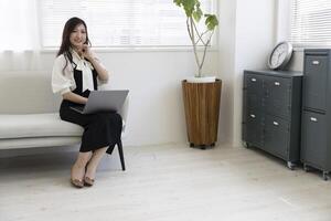 een Japans vrouw controle smartphone door afgelegen werk in de huis kantoor foto