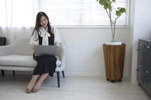 een Japans vrouw controle smartphone door afgelegen werk in de huis kantoor foto