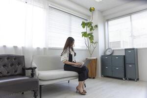 een Japans vrouw controle smartphone door afgelegen werk in de huis kantoor foto