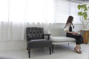 een Japans vrouw controle smartphone door afgelegen werk in de huis kantoor foto