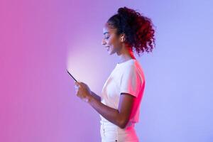 zwart dame met telefoon en oortelefoons tegen levendig helling achtergrond foto