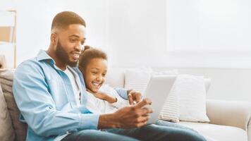 vader en dochter aan het kijken film Aan tablet foto