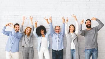 verschillend mensen tonen positief gebaren, poseren samen over- wit muur achtergrond foto