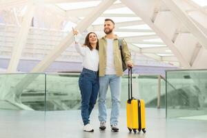 gelukkig jong paar genieten van hun tijd Bij de luchthaven terwijl aan het wachten vlucht foto