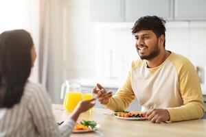 vrolijk millennial Indisch Mens hebben ontbijt met zijn vriendin foto