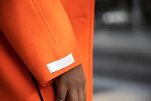 dichtbij omhoog van luxueus oranje kasjmier kleding stof Aan jas. foto