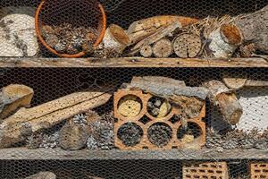 een insect hotel achter een metaal rooster foto