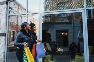 twee gelukkig Afrikaanse Amerikaans meisje vrienden gaan boodschappen doen foto