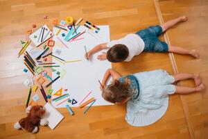 kinderen tekening Aan verdieping Aan papier. peuter- jongen en meisje Speel Aan verdieping met leerzaam speelgoed - blokken, trein, spoorweg, vlak. speelgoed voor peuter- en kleuterschool. kinderen Bij huis of kinderopvang. top visie. foto