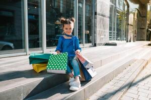 portret van mooi glimlachen weinig meisje vervelend met boodschappen doen zak buitenshuis foto