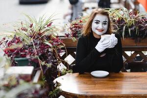 mime komiek drinken koffie. meisje mime drankjes koffie in Parijs. foto