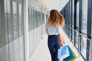 mooi jong vrouw met Tassen in boodschappen doen centrum foto