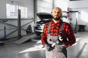 monteur werken en Holding moersleutel van onderhoud bestellen voor onderhouden auto Bij de reparatie winkel foto