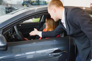 bedrijf vrouw koopt een auto Bij een auto dealerschap. concept van gelukkig bedrijf mensen foto